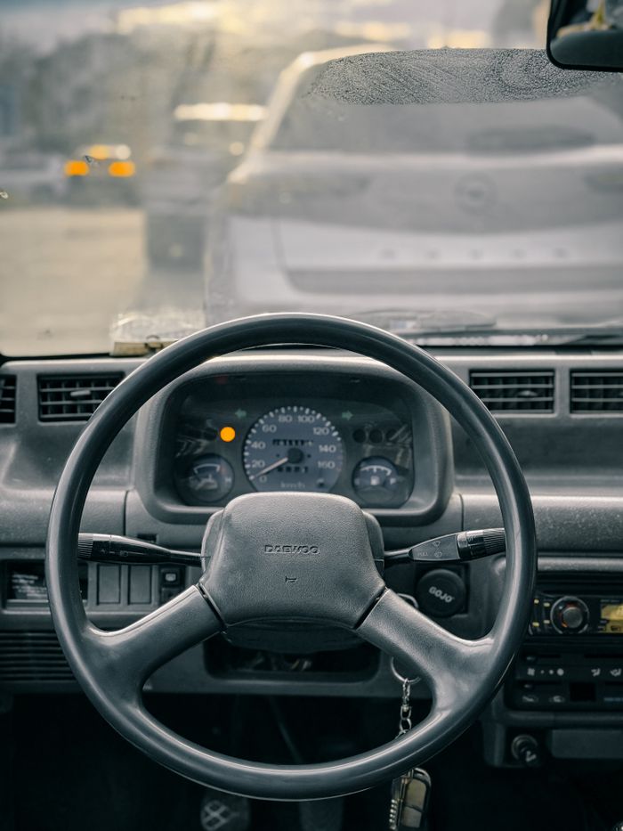 services-01 Interior view of a vintage car with focus on steering wheel and dashboard.