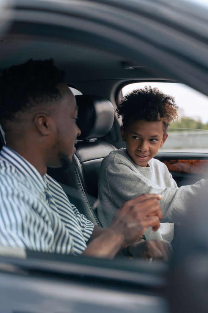 services-img Father and son bonding inside a car, focusing on driving lessons and family time.